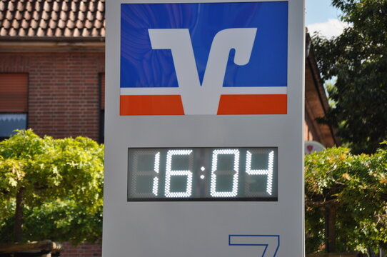 Volksbanklogo und digitale Uhr: S&auml;ule mit Leuchtschrift und Anzeigentafel vor der Bankfiliale: