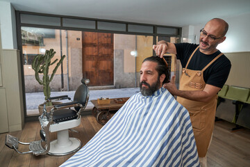 Barber combing hair of client in salon