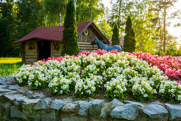 Park z drzewami liściastymi, pięknymi trawnikami, klombami kolorowych kwiatów i alejkami. Lato na Śląsku w Polsce, Rogów gmina Gorzyce. © Franciszek