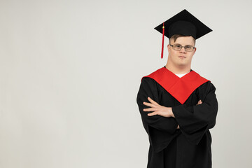 Smiling young man with cerebral palsy wearing glasses in a graduate suit. World Genetic Diseases...