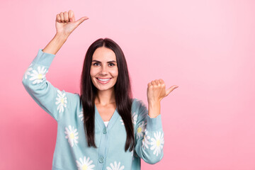 Portrait of satisfied gorgeous girl wear flower print pullover two hands indicating at sale empty space isolated on pink color background