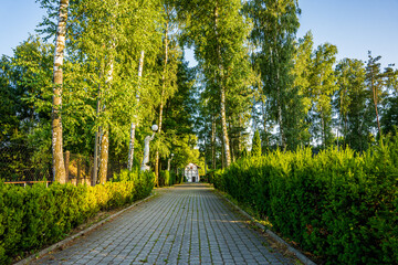 Park z drzewami liściastymi, pięknymi trawnikami, klombami kolorowych kwiatów i alejkami. Lato na Śląsku w Polsce, Rogów gmina Gorzyce.