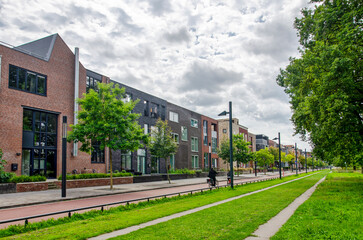 Enschede, The Netherlands, August 9, 2023: long facade with residential buildings along the central...
