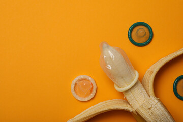 Condom on a banana on a yellow background,place for text