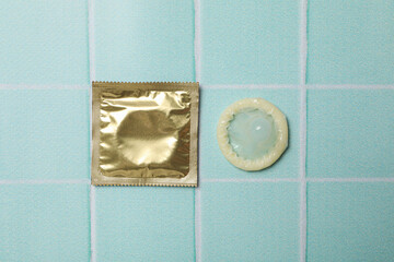 Sealed and opened condoms on a blue background