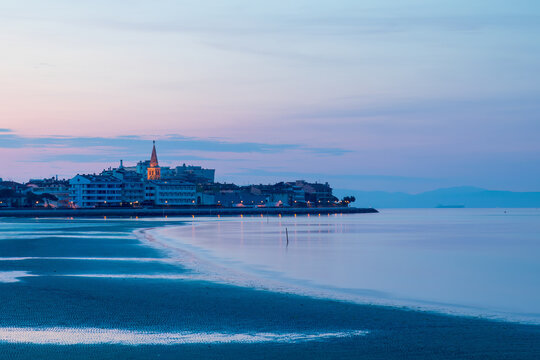 Alba sulla citt&agrave; di Grado, vista dalla spiaggia. Visibile ed illuminato il campanile della basilica si Sant' Eufemia.
