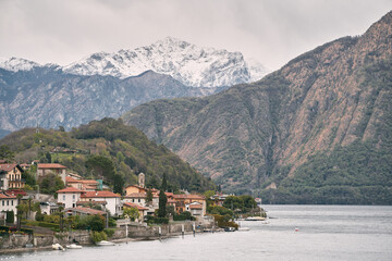 italian village on the lake with alps background. View of village on Como Lake, Milan, Italy with Alps mountains in background.