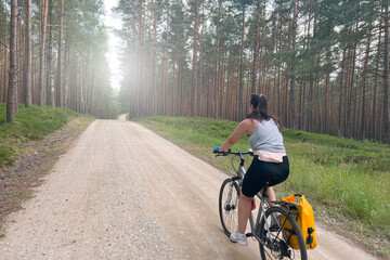 Naklejka premium Woodland Adventure. Girl Cycling Through Nature's Beauty. Concept of recreation in nature.