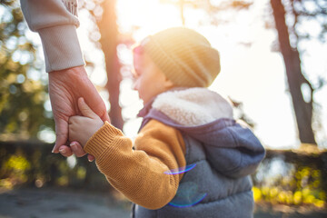 Mother holding hand of little son. Mother and son holding hand in hand. Mother and son holding...