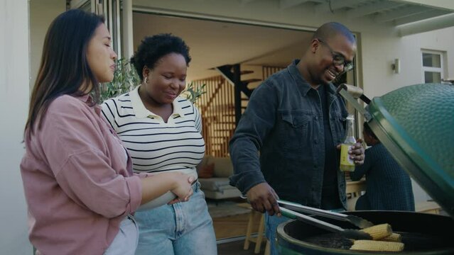 Two Women and a Black Man Cooking lunch on a BBQ