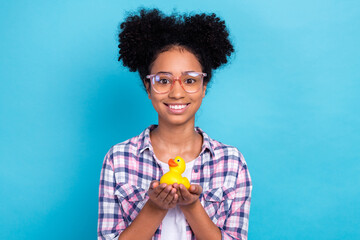 Photo of toothy beaming girl with perming coiffure dressed checkered shirt in glasses hold duck toy...