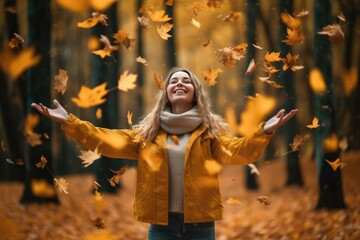 Autumn happy mood, positive emotions as a remedy for autumn depression. Autumn photo of happy beautiful girl with curly hair throws autumn leaves in fall park.