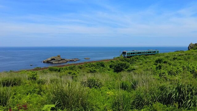 種差海岸の海沿いを走る八戸線の列車