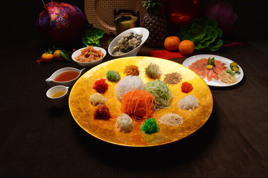 fresh colourful asian festive vegetables salad lo hei yu sheng with smoked salmon, fish skin, cookies and sweet spicy sauce buffet corner for chinese new year halal food menu for banquet restaurant
