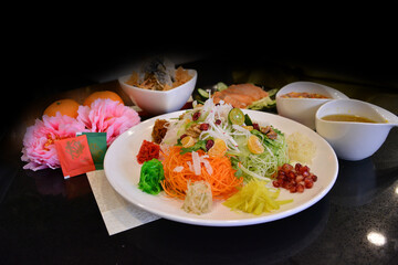 fresh colourful asian festive vegetables salad lo hei yu sheng with smoked salmon, fish skin,...