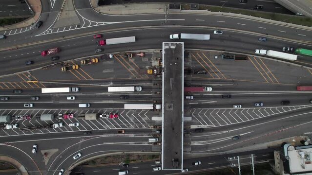 Trucks and cars going through EZ Pass Toll Plaza in New York, 4K overhead aerial.