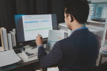 Asian male businessman working in the room. Startup company employees are working in the office at night, overtime, busy work, hard work. Overtime concept.