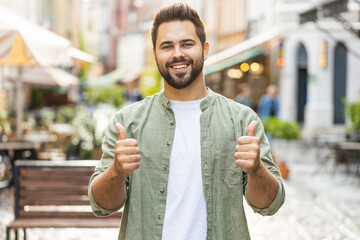 Like. Happy bearded young man looking approvingly at camera showing thumbs up, like sign positive...