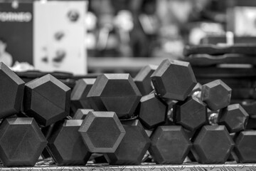 Rack with dumbbells and fitness accessories are sold in a sports store. Functional training and...