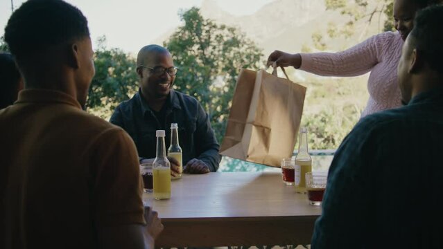 An African Woman Bringing Food to a Picnic Table With Friends