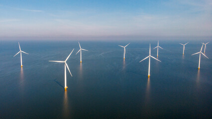 Windmill park with clouds and a blue sky, wind mill turbines in the ocean aerial view with wind turbine Flevoland Netherlands Ijsselmeer. Green Energy production in the Netherlands - obrazy, fototapety, plakaty