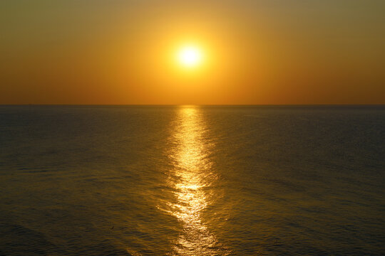 Sunset with sun path on surface of sea.