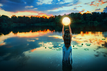 Art photo magic Fantasy woman and moon, holding universe planet in hands raises to dark night sky....