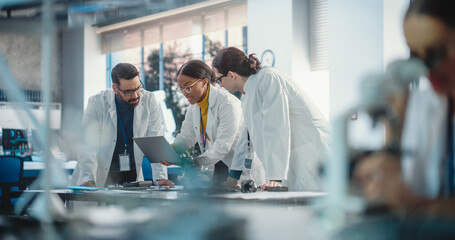 Diverse Young Group of Engineers Working in a Startup Company Lab. Project Managers Discuss...