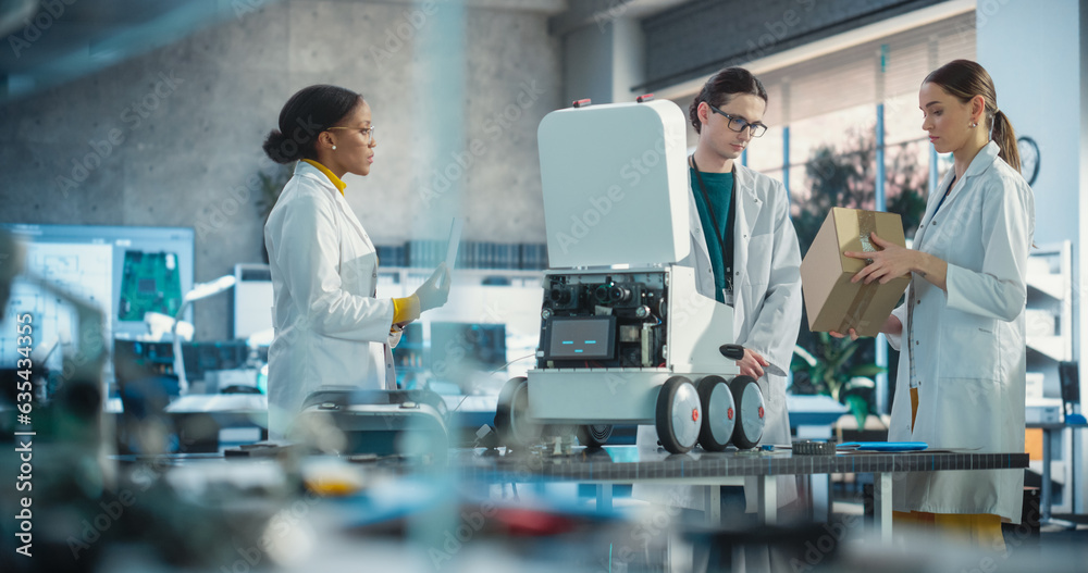 Poster Team of Industrial Specialists Working on Mobile Robot, Using a Laptop. Young Male and Female Engineers in a Lab Discussing an Automated AI Robotic Delivery Assistant, Brainstorming Improvement Ideas