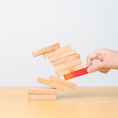 woman hand pulling wood domino blocks on table. Crisis, fall Business, Risk management, Economic recession, Strategy and solutions concept