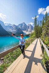 Woman taking a selfie, Moraine Lake during summer in .Banff National Park, Canadian Rockies, Alberta, Canada...Banff National Park, Alberta, Canada