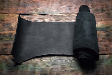 Leather rolls on the old wooden workbench background top view. Leather craft concept background.