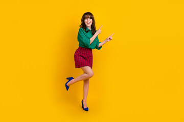 Fototapeta na wymiar Full length photo of pretty sweet lady wear green shirt pointing two fingers empty space isolated yellow color background