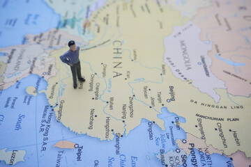 Naklejka premium miniature man on world map it can use for travelling photo concept