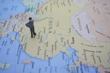 miniature man on world map it can use for travelling photo concept