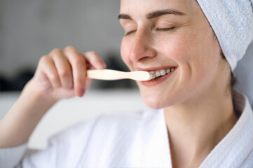 Close up of smiling woman brushing white, straight teeth