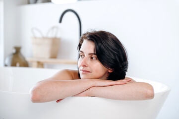 Portrait of woman leaning on arms while enjoying water procedure