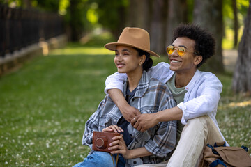 Young cute couple sitting on the grass and looking romantic