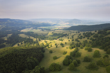Obraz premium Summer landscape with hills and trees in the warm sunrise light