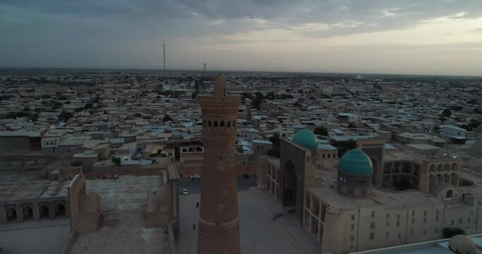 A drone flies around the famous memorial complex Kalyan Poi Kalon Complex and Poi Kalon Minaret, Poi Kalan or Po-i-Kalyan in Bukhara at dawn