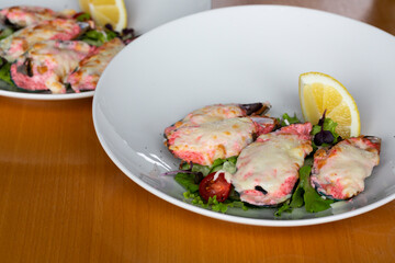 baked mussels with masago caviar and cheese on a white plate