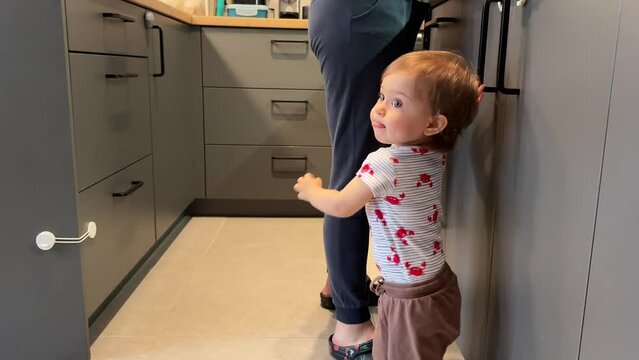 One year old child looking trough the kitchen drawer