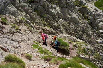 Women hiking on a trail in the rocky mountains