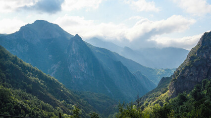 Fototapeta na wymiar Sunbeams between the clouds and mountains of Somiedo, Asturias
