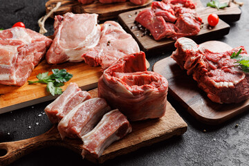 Fresh meat pork ribs with green on wooden board, top view on dark background