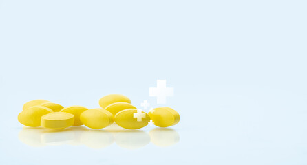 Yellow tablets pill with white cross symbol on white background. Health and medical care concept. Health insurance. Pharmacy department banner in hospital. Pharmaceutical industry. Pharmacy product.