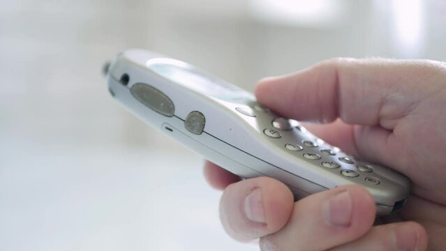 Closeup Blurred Shooting with a Businessman Texting or Dialing a Phone Number Using Old Mobile Technology. Man Using a Cellphone.