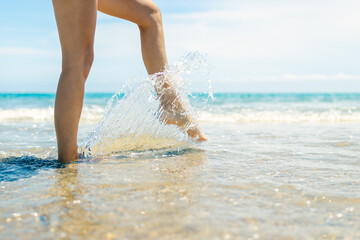 close-up of female legs walk on the water on the beach, there is a place for an inscription,seascape