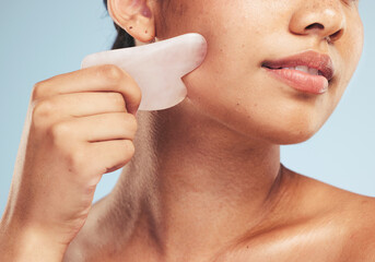 Skincare, gua sha and woman with face massage on studio for anti aging, wellness and circulation on...