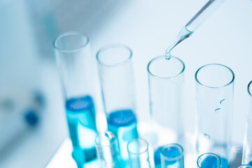 Close up of scientist is dropping blue liquid substance in science test tube in laboratory. Concept of science, biochemistry, chemical, diagnosis, biotechnology. Substance study analyzing experiment